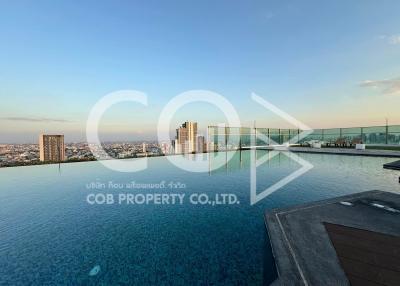 Rooftop swimming pool with city skyline view at dusk