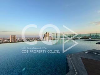 Rooftop swimming pool with city skyline view at dusk