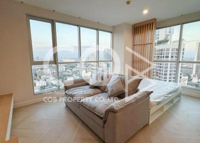 Spacious living room with large windows and city view