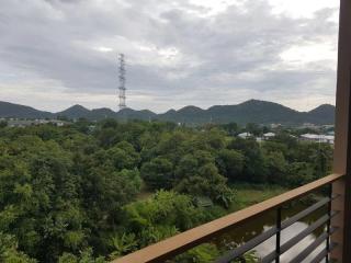 Scenic view from a balcony overlooking lush greenery and mountains