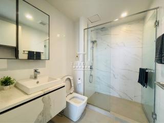 Modern bathroom with marble tiles, glass shower, and sleek fixtures