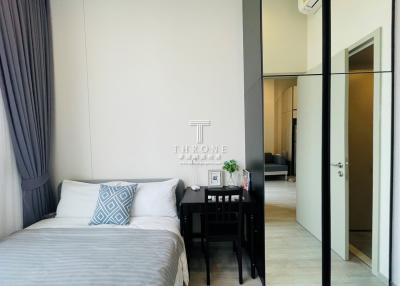 Modern bedroom with a queen-sized bed, sleek black bedside table, and a mirrored wardrobe