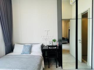 Modern bedroom with a queen-sized bed, sleek black bedside table, and a mirrored wardrobe