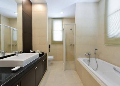 Spacious modern bathroom with a shower cabin, bathtub and large vanity mirror