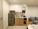 Modern compact kitchen with light wood cabinetry and stainless steel appliances