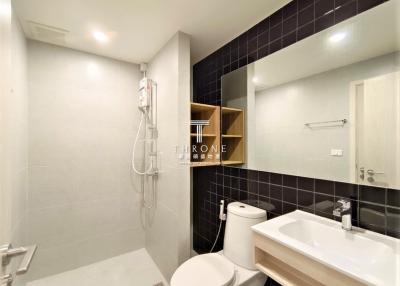 Modern bathroom with white fixtures and dark tiles
