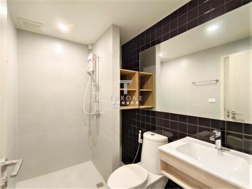 Modern bathroom with white fixtures and dark tiles