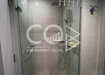 Modern bathroom with glass shower enclosure and beige wall tiles