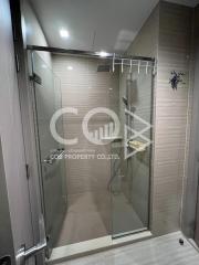 Modern bathroom with glass shower enclosure and beige wall tiles