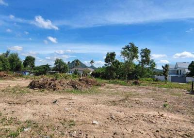 Spacious undeveloped land with scenic mountain backdrop under a clear blue sky