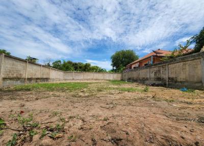 Spacious empty yard with blue sky and boundary walls
