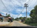 Paved street view with power lines and houses in a suburban area