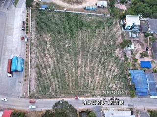 Aerial view of a spacious vacant land plot with nearby housing and vegetation, suitable for development