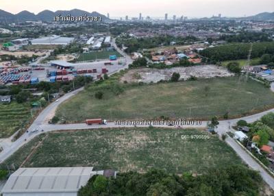 Aerial view of an empty land plot for sale with city and mountains in the background