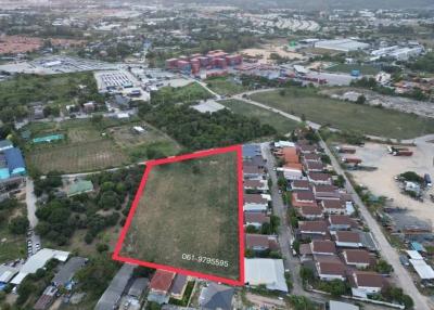 Aerial view of an open plot of land for sale within a developed area