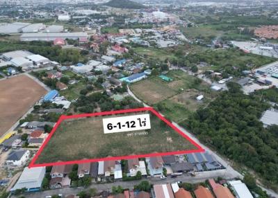 Aerial view of a property lot with boundaries marked, near residential and industrial areas