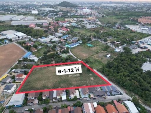 Aerial view of a property lot with boundaries marked, near residential and industrial areas