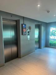 Modern building lobby with elevator access and digital directory