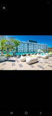 Luxurious hotel building with poolside lounge area under clear blue skies