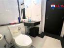 Compact modern bathroom with white tiles, toilet, and sink