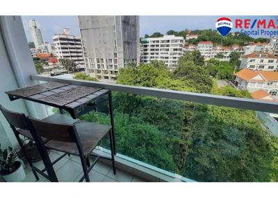 Compact balcony with a table and chair overlooking cityscape