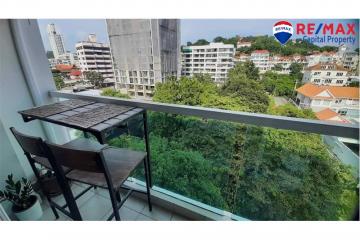 Compact balcony with a table and chair overlooking cityscape