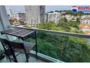 Compact balcony with a table and chair overlooking cityscape