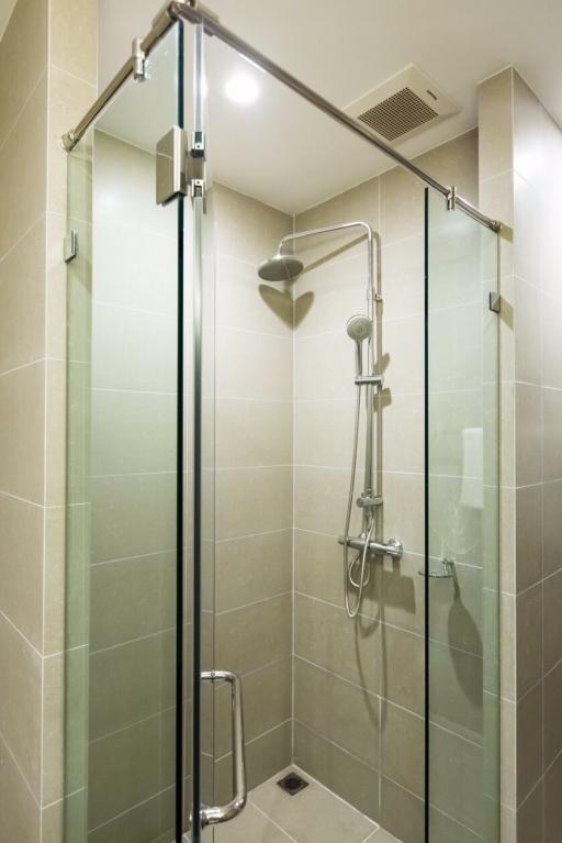 Modern bathroom with glass shower enclosure and tiled walls