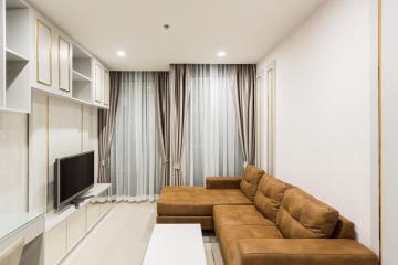 Modern living room with a comfortable brown sofa and flat-screen TV