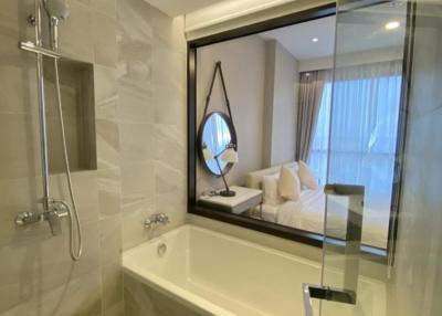 Modern bathroom with glass shower partition and view into the bedroom