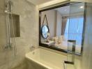 Modern bathroom with glass shower partition and view into the bedroom