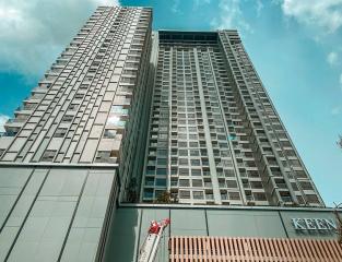 Exterior view of a modern high-rise residential building with clear blue sky in the background