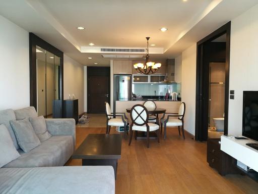 Spacious living room with modern furnishings, adjacent to an open dining area