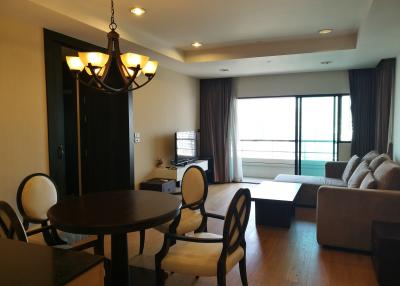 Spacious living room with natural lighting, dining area, and balcony access