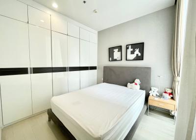 Neat and modern bedroom with a large bed and built-in wardrobes