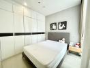 Neat and modern bedroom with a large bed and built-in wardrobes