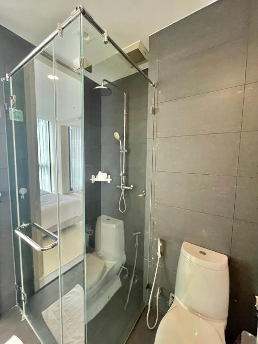 Modern bathroom with glass shower enclosure and grey tiles