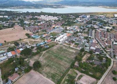 Aerial view of a residential area with a vacant land plot in the foreground