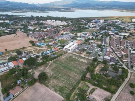 Aerial view of a residential area with a vacant land plot in the foreground