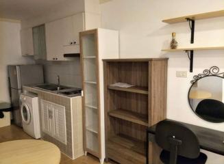 Compact kitchen with modern appliances and wooden shelving