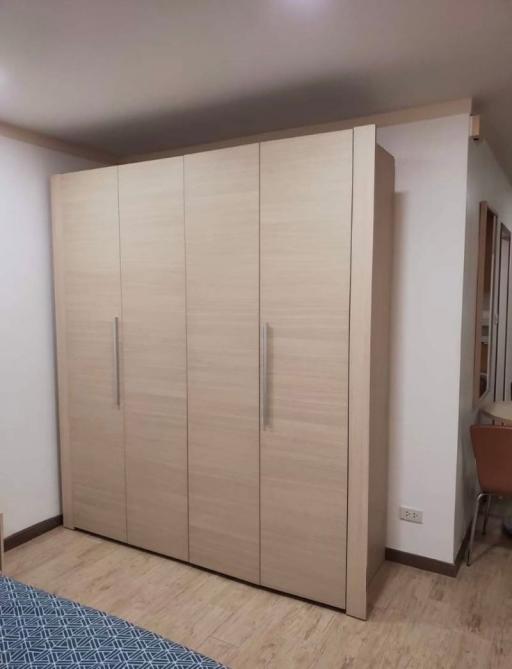 Spacious bedroom with a large wooden wardrobe