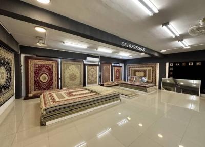 Spacious showroom interior with various oriental carpets on display and reflective flooring