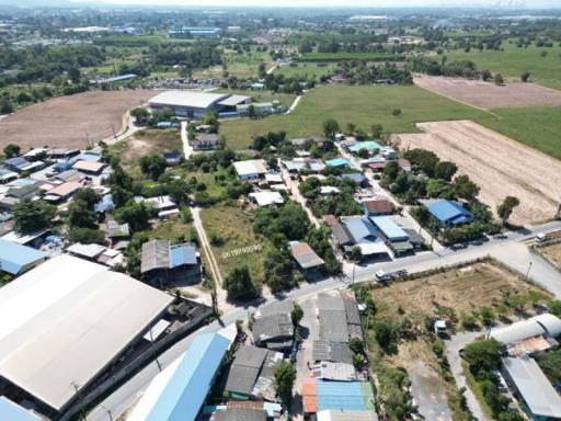 Aerial view of a rural area with mix of agricultural land, residential properties, and industrial buildings