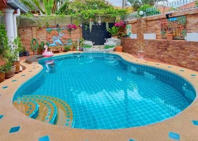 Inviting outdoor swimming pool with surrounding garden and sitting area in a residential property