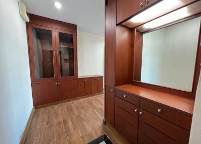 Spacious hallway with built-in wooden cabinetry and ample lighting