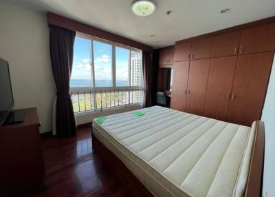 Spacious bedroom with ocean view and hardwood floors