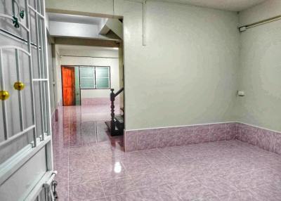 Empty interior space with pink tiled flooring and white walls