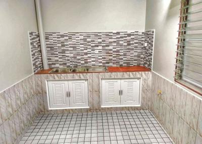 Compact kitchen with mosaic backsplash and white cabinetry