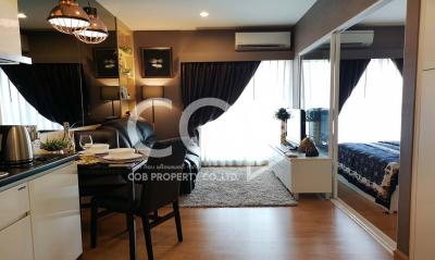 Modern furnished apartment living and dining area with open bedroom view