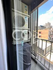 Balcony view with air conditioning units and urban backdrop